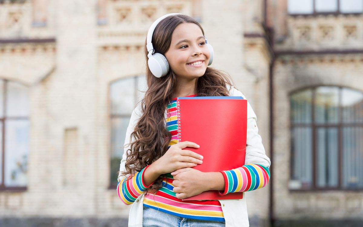 niña con cascos y libros